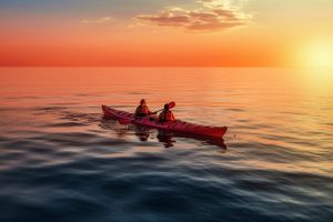 a couple kayaking at sunset