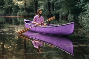a man in a purple canoe
